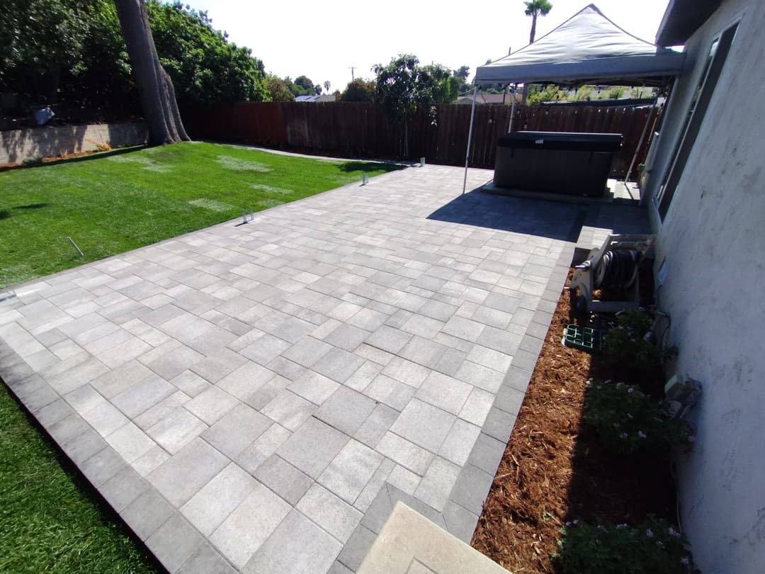 finished backyard with large pavers and artificial turf