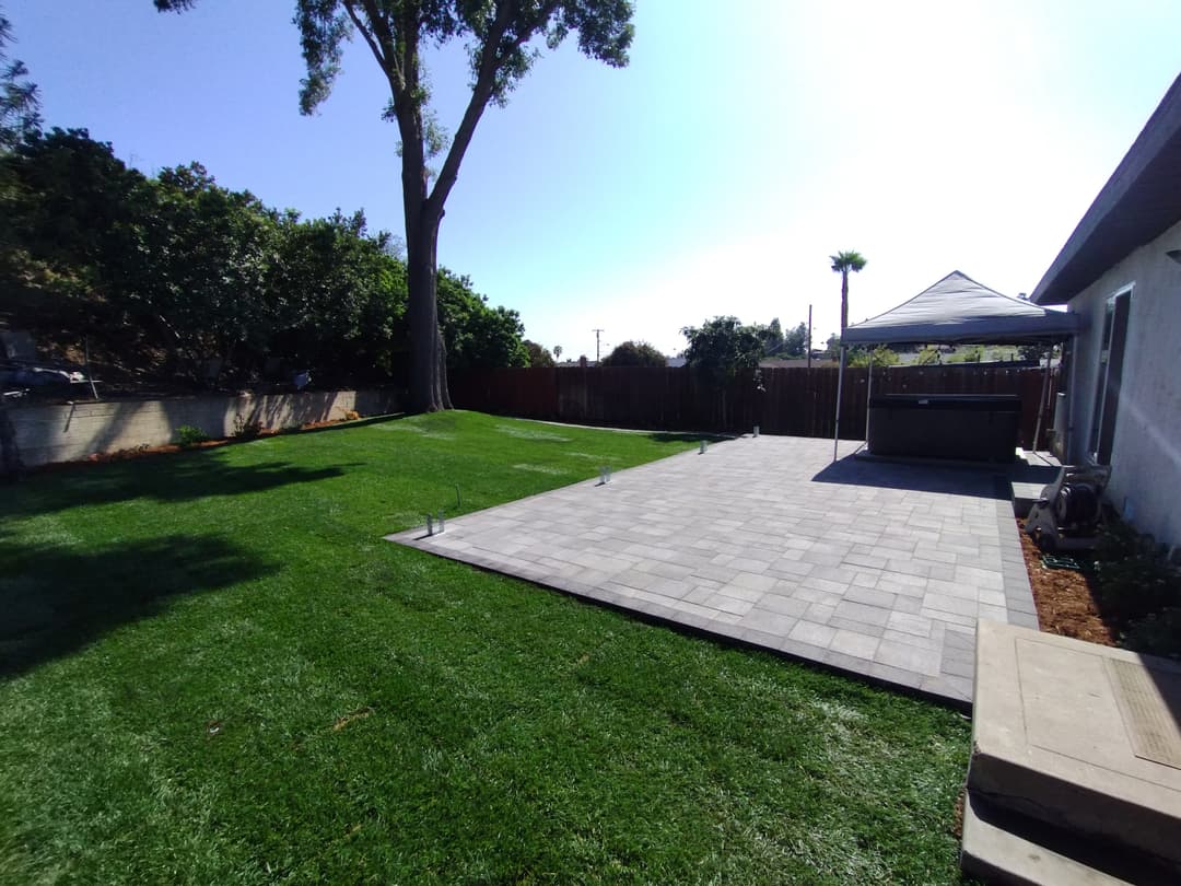 backyard with paver patio, artificial turf, and canopy